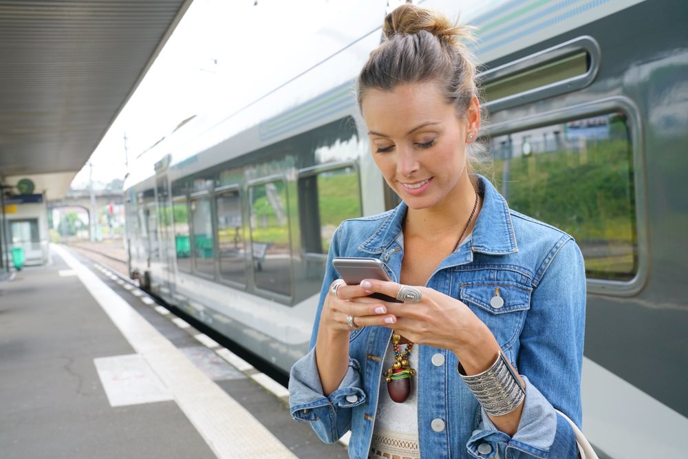 student using smartphone app at train station iPhone battery slowdown update