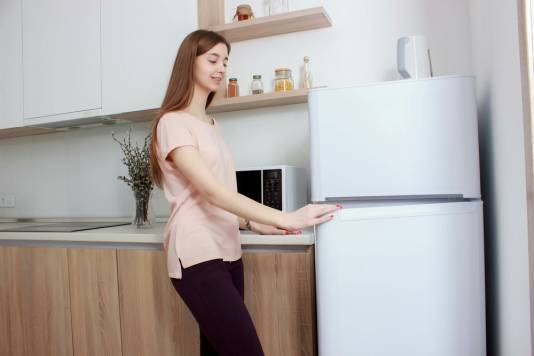 woman opening door of fridge freezer