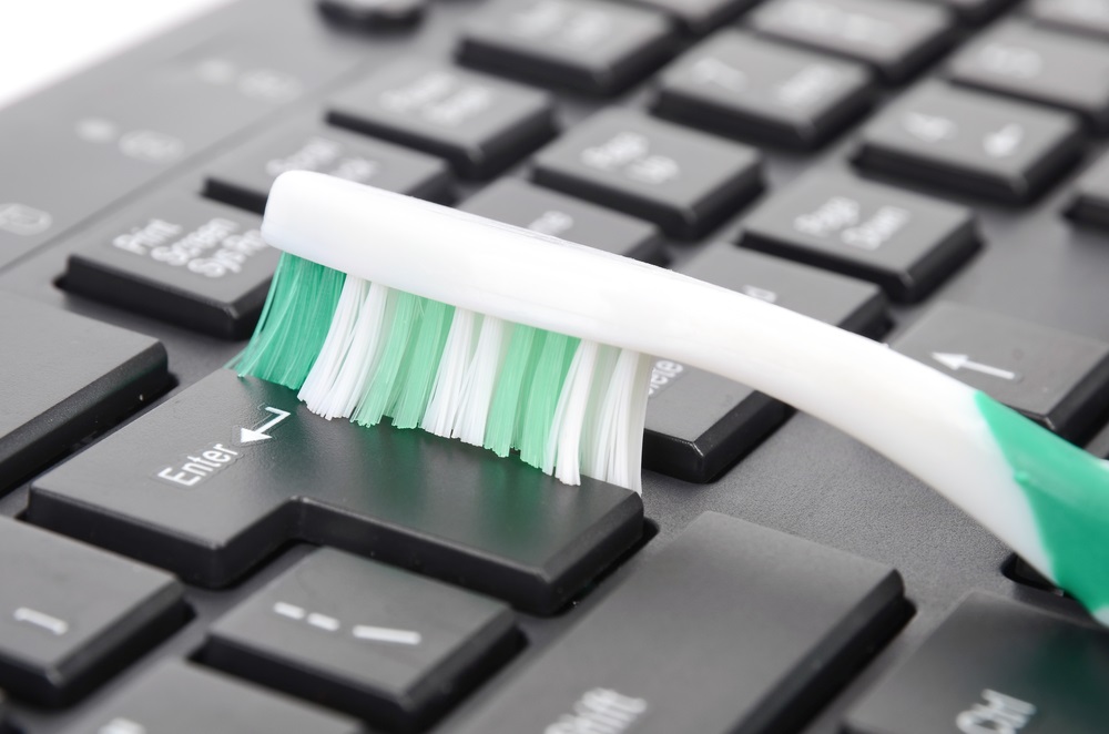 cleaning keyboard with a toothbrush - Ebuyer Blog